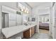 Bathroom featuring a long countertop, wooden cabinets, large mirror, and tile flooring at 19225 N Tallowood Way, Surprise, AZ 85387