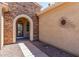 Arched entrance with decorative glass door and stone surround with desert landscaping at 19225 N Tallowood Way, Surprise, AZ 85387