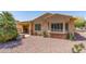 Charming home exterior with bay windows, stone accents, desert landscaping, and covered patio at 19225 N Tallowood Way, Surprise, AZ 85387