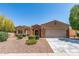 Charming single-story home with a two-car garage, stone accents, and desert landscaping at 19225 N Tallowood Way, Surprise, AZ 85387