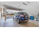 Spacious garage featuring ample storage, an open door, and a car parked inside at 19225 N Tallowood Way, Surprise, AZ 85387