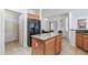 Spacious kitchen featuring granite counters, an island, and tile floors at 19225 N Tallowood Way, Surprise, AZ 85387