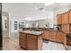 Spacious kitchen featuring granite counters, an island, and tile floors at 19225 N Tallowood Way, Surprise, AZ 85387