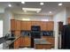 Functional kitchen featuring abundant wood cabinets, skylight, and black appliances at 19225 N Tallowood Way, Surprise, AZ 85387