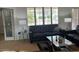 Comfortable living room with large windows, shutters, and a sleek black leather couch at 19225 N Tallowood Way, Surprise, AZ 85387