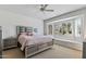 Serene bedroom featuring a ceiling fan and bay window at 19225 N Tallowood Way, Surprise, AZ 85387