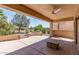 Covered patio featuring concrete flooring, stone accents, ceiling fan, and scenic backyard view at 19225 N Tallowood Way, Surprise, AZ 85387