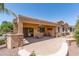 Inviting covered patio with stone pillars, desert landscaping, and seamless indoor-outdoor living at 19225 N Tallowood Way, Surprise, AZ 85387