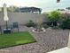 Landscaped backyard with stone, artificial turf, flowers and mature plantings at 20298 N 108Th Ln, Sun City, AZ 85373