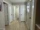 Neutral hallway featuring multiple closets and vinyl flooring at 20298 N 108Th Ln, Sun City, AZ 85373