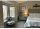 Bright main bedroom features a plush bed, soft lighting, and a sitting area at 20298 N 108Th Ln, Sun City, AZ 85373