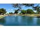 Scenic pond featuring a fountain, lush greenery, walking paths, and park benches at 20298 N 108Th Ln, Sun City, AZ 85373