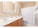 Bathroom with double sink vanity and shower with a white curtain, framed by light neutral walls at 20423 W Springfield St, Buckeye, AZ 85396