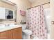 Cozy bathroom with decorative shower curtain, vanity with sink, and a framed mirror above the toilet at 20423 W Springfield St, Buckeye, AZ 85396