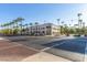 An exterior image of a well-maintained building with lush landscaping, featuring palm trees and a beautiful blue sky at 20423 W Springfield St, Buckeye, AZ 85396