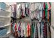 Walk-in closet with rows of hanging clothes, shelving, and storage baskets at 20423 W Springfield St, Buckeye, AZ 85396