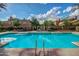 Spacious community pool with clear blue water, surrounded by lounge chairs and well-manicured landscaping at 20423 W Springfield St, Buckeye, AZ 85396