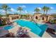 Aerial view of the luxurious community pool featuring a hot tub, cabana, ample seating, and lush landscaping at 20423 W Springfield St, Buckeye, AZ 85396