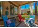 Inviting front porch with rocking chairs, neutral rug, sheer curtains and privacy at 20423 W Springfield St, Buckeye, AZ 85396