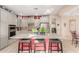 Kitchen features granite island with bar seating, tile floors, stainless appliances and grey cabinets at 20423 W Springfield St, Buckeye, AZ 85396