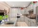 Galley kitchen features grey cabinets, stainless appliances and a modern sink with view of a lovely granite countertop at 20423 W Springfield St, Buckeye, AZ 85396