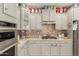 Kitchen features grey cabinets, granite countertop, stainless appliances and decorative backsplash at 20423 W Springfield St, Buckeye, AZ 85396