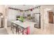 Eat-in kitchen features granite island with bar seating, tile floors, stainless steel appliances, and grey cabinets at 20423 W Springfield St, Buckeye, AZ 85396