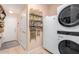 Laundry room featuring stacked washer/dryer, shelving, and access to an exit door at 20423 W Springfield St, Buckeye, AZ 85396