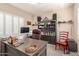Home office with built-in shelving, ample desk space, and shuttered windows for privacy at 20423 W Springfield St, Buckeye, AZ 85396