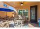 Inviting covered patio with fan, comfortable seating, and an umbrella for shade, creating an outdoor oasis at 20423 W Springfield St, Buckeye, AZ 85396