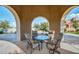 Covered patio featuring a round table and four chairs with a view of the beautifully landscaped yard at 20423 W Springfield St, Buckeye, AZ 85396