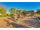 A fun community playground features a variety of equipment, including slides, swings, and climbing structures, set on woodchips at 20423 W Springfield St, Buckeye, AZ 85396
