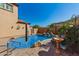 Beautiful backyard oasis featuring a sparkling pool, rock waterfall, and vibrant desert landscaping in a private setting at 20423 W Springfield St, Buckeye, AZ 85396