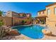 Stunning backyard pool with rock features, desert landscaping, and a covered patio, perfect for relaxation at 20423 W Springfield St, Buckeye, AZ 85396
