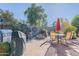 Outdoor patio area features a dining table, grill, desert landscaping, and a fire pit at 20581 N Enchantment Pass, Maricopa, AZ 85138