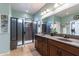Modern bathroom featuring double sinks, granite countertop, tiled floors, glass enclosed shower, and ample cabinet space at 20581 N Enchantment Pass, Maricopa, AZ 85138