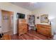 Secondary bedroom featuring wood floors, ample storage, dresser, and neutral color palette at 20581 N Enchantment Pass, Maricopa, AZ 85138