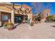 Welcoming clubhouse entrance with beautiful landscaping, elegant columns, and a charming sign at 20581 N Enchantment Pass, Maricopa, AZ 85138