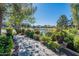 Picturesque lakeside path with lush landscaping, flowers, and mature trees at 20581 N Enchantment Pass, Maricopa, AZ 85138