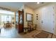 Inviting entryway with neutral paint, tile floors, chair, and wood accents, offering a warm welcome to the home at 20581 N Enchantment Pass, Maricopa, AZ 85138