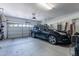 Well-organized garage with a car, bikes, overhead storage, and side door at 20581 N Enchantment Pass, Maricopa, AZ 85138