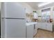 A convenient laundry room with modern appliances, counter space, and ample storage at 20581 N Enchantment Pass, Maricopa, AZ 85138