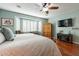 Comfortable main bedroom featuring hardwood floors, plantation shutters, and a modern ceiling fan at 20581 N Enchantment Pass, Maricopa, AZ 85138
