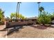 This backyard has palm trees, rock landscaping, and a privacy fence at 2114 E Hale St, Mesa, AZ 85213