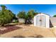 This backyard features a storage shed, rock landscaping, and mature trees at 2114 E Hale St, Mesa, AZ 85213