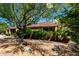 Beautiful desert landscaping surrounds the home in this sunny shot showing well-manicured grounds and mature shade trees at 2114 E Hale St, Mesa, AZ 85213