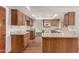 Bright kitchen boasts wooden cabinetry, modern appliances, skylight, and ample counter space for meal preparation at 2114 E Hale St, Mesa, AZ 85213
