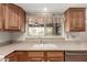 Charming kitchen has wooden cabinets, a double basin sink, and a window with a view of the outdoors at 2114 E Hale St, Mesa, AZ 85213