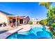 Beautiful backyard with sparkling pool, covered patio, and lush landscaping under clear blue sky at 2189 W Mila Way, San Tan Valley, AZ 85144