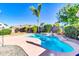 Private backyard with sparkling pool, mature palm tree, and lush landscaping under bright blue sky at 2189 W Mila Way, San Tan Valley, AZ 85144